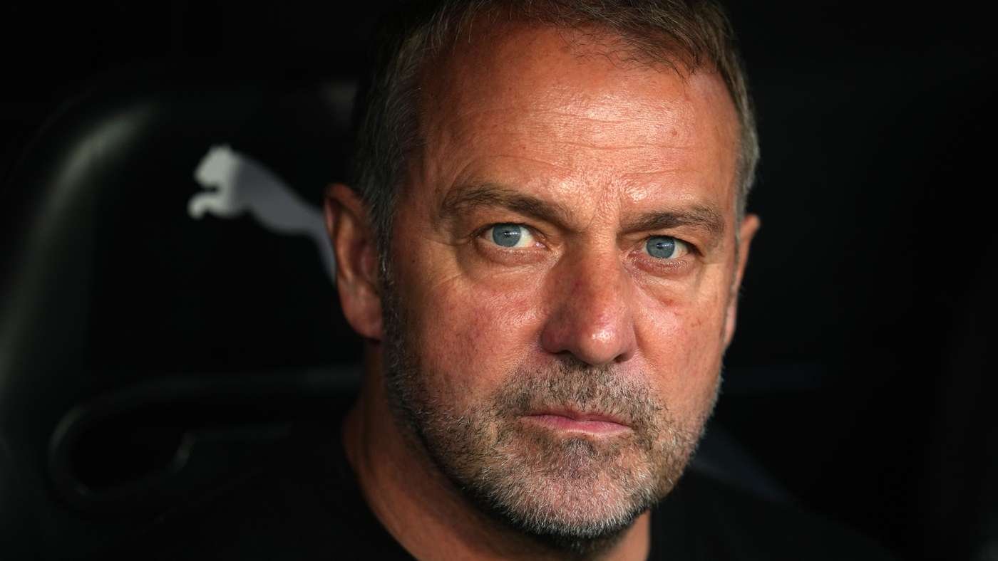 Close-up portrait of a middle-aged man with blue eyes and a salt-and-pepper beard against a dark background.