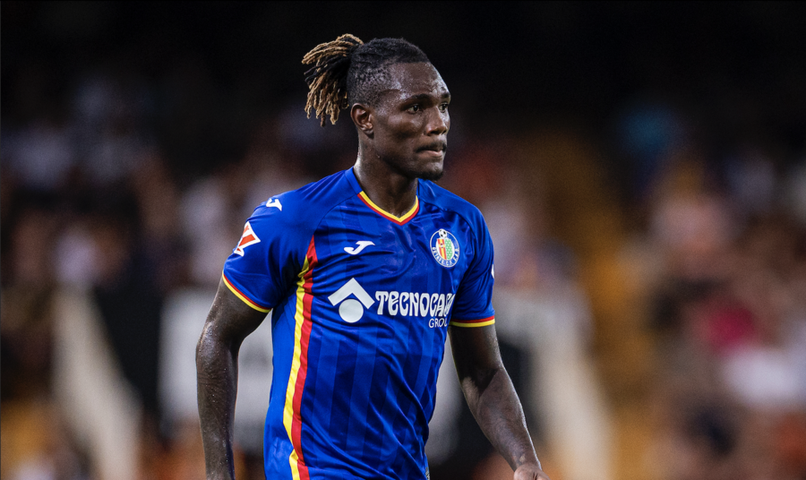 Soccer player in a blue jersey on the field, looking to the side during a match.